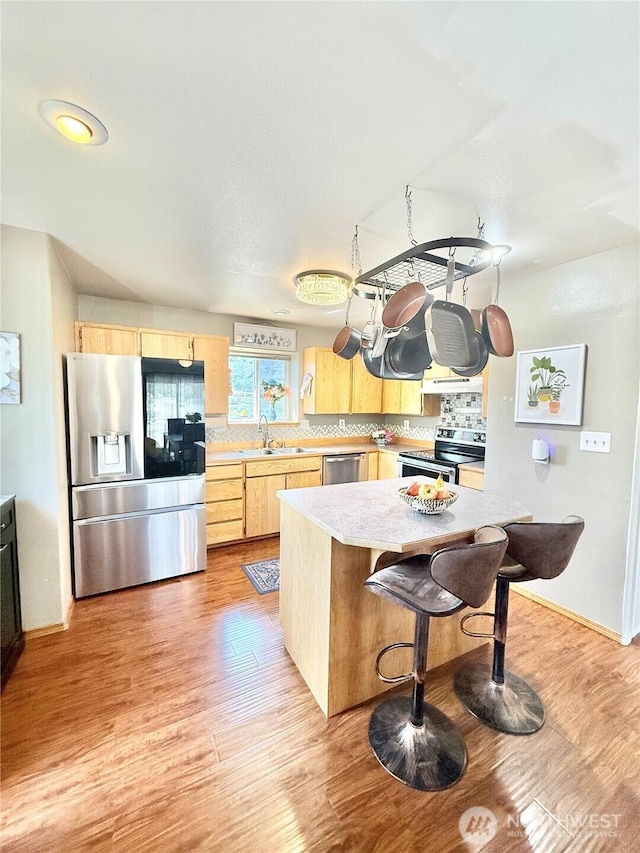47 Kruse St, Omak, WA 98841 - kitchen with appliances with stainless steel finishes, light brown cabinetry, light wood finished floors, and tasteful backsplash