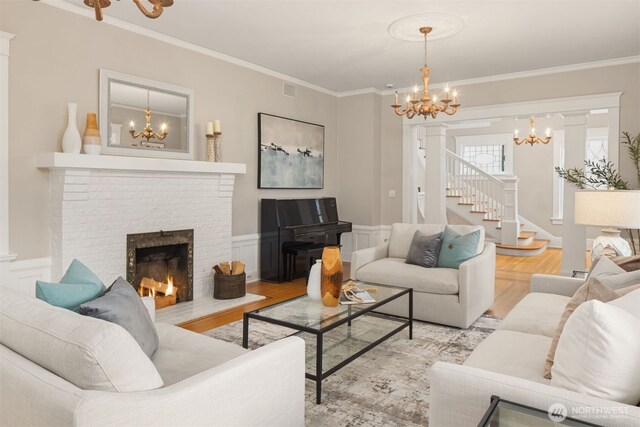 1611 Mcgilvra Blvd E, Seattle, WA 98112 - living room featuring a chandelier, ornamental molding, light wood finished floors, stairs, and a fireplace
