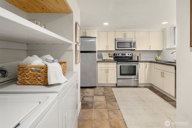 1611 Mcgilvra Blvd E, Seattle, WA 98112 - kitchen featuring stainless steel appliances, a sink, washing machine and clothes dryer, backsplash, and recessed lighting