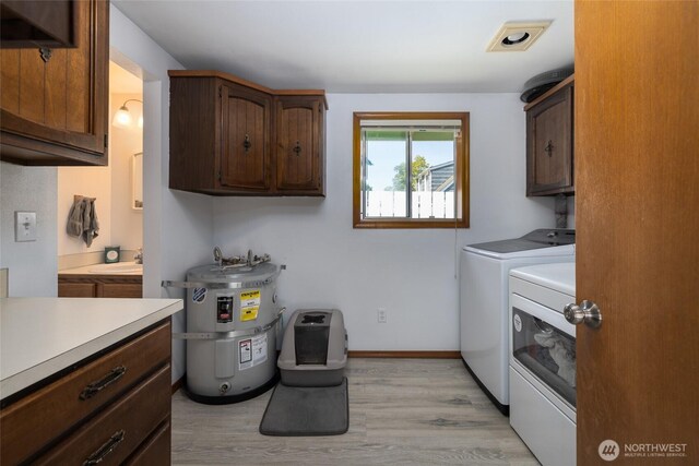 23696 Lake Dr, Mount Vernon, WA 98273 - washroom with cabinet space, water heater, washer and dryer, and light wood finished floors