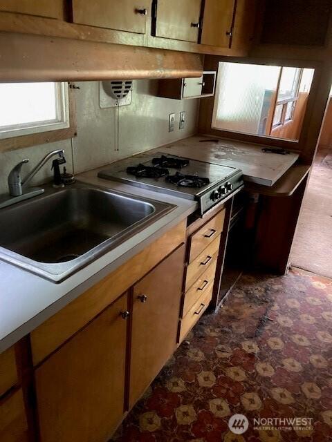 40 N Silver Ln, Hoodsport, WA 98548 - kitchen featuring a sink, tile patterned floors, light countertops, stovetop, and brown cabinets