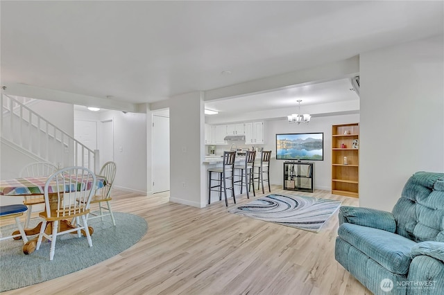 3939 10th St SE Unit A2, Puyallup, WA 98374 - living room featuring light wood-type flooring, a chandelier, stairway, and baseboards