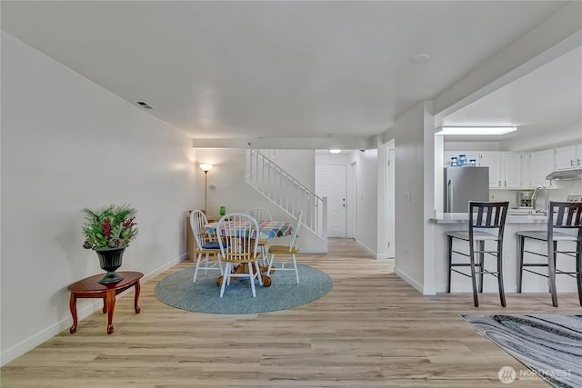 3939 10th St SE Unit A2, Puyallup, WA 98374 - dining room with stairway, baseboards, and light wood-style flooring
