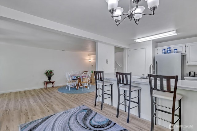 3939 10th St SE Unit A2, Puyallup, WA 98374 - dining area featuring light wood finished floors, a chandelier, and baseboards