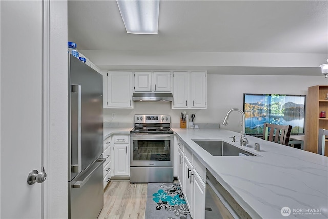 3939 10th St SE Unit A2, Puyallup, WA 98374 - kitchen with stainless steel appliances, under cabinet range hood, a sink, light stone counters, and white cabinets