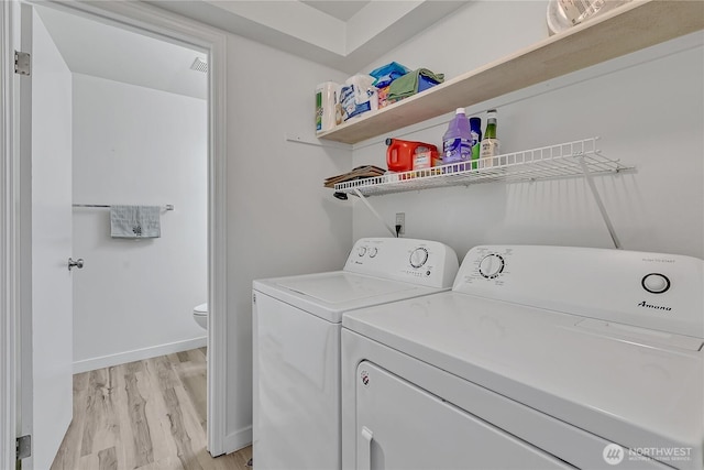 3939 10th St SE Unit A2, Puyallup, WA 98374 - laundry area featuring washer and dryer, light wood-style floors, and baseboards