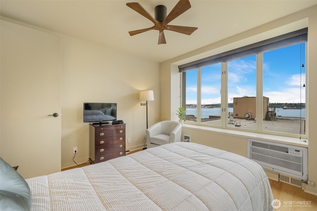 98 Union St Unit 301, Seattle, WA 98101 - bedroom with a wall mounted air conditioner, wood finished floors, ceiling fan, and baseboards