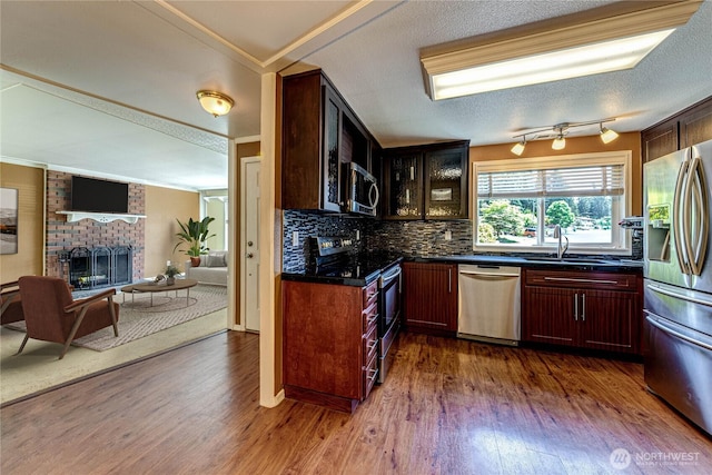 5611 128th Pl SE, Everett, WA 98208 - kitchen with stainless steel appliances, dark countertops, dark wood-style floors, open floor plan, and backsplash