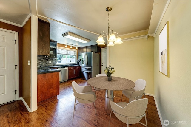 5611 128th Pl SE, Everett, WA 98208 - dining area with a chandelier, ornamental molding, dark wood-style flooring, and baseboards