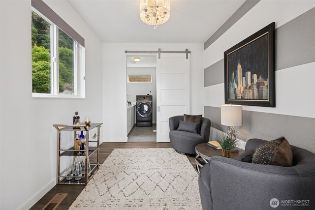 6720 Soundview Dr NE, Tacoma, WA 98422 - living area featuring a barn door, washer / clothes dryer, dark wood finished floors, and a chandelier