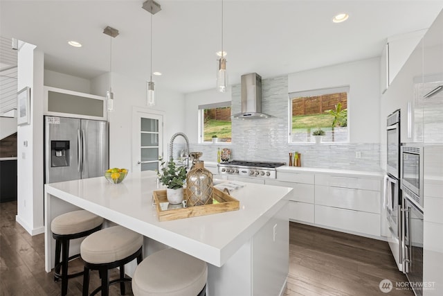 6720 Soundview Dr NE, Tacoma, WA 98422 - kitchen with wall chimney range hood, modern cabinets, appliances with stainless steel finishes, light countertops, and dark wood-style flooring