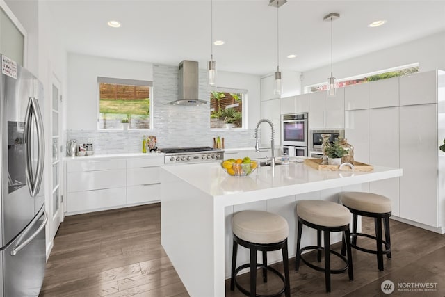 6720 Soundview Dr NE, Tacoma, WA 98422 - kitchen with stainless steel appliances, wall chimney exhaust hood, modern cabinets, decorative backsplash, and dark wood-type flooring