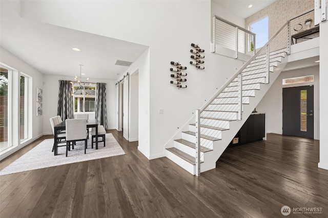 6720 Soundview Dr NE, Tacoma, WA 98422 - dining space with stairway, a chandelier, dark wood-style floors, a towering ceiling, and recessed lighting