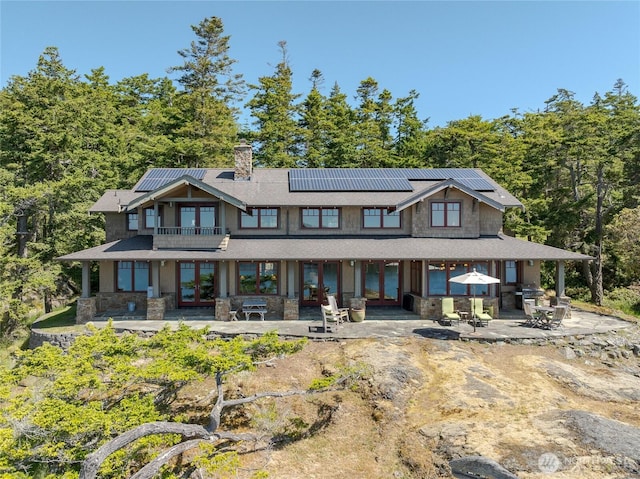 481 Grimes Riker Ln, Lopez Island, WA 98261 - rear view of property with french doors, a patio area, roof mounted solar panels, a balcony, and a chimney