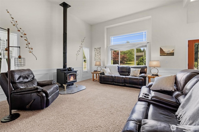11024 127th Ave NE, Lake Stevens, WA 98258 - carpeted living room featuring a wood stove, high vaulted ceiling, a wainscoted wall, and a decorative wall