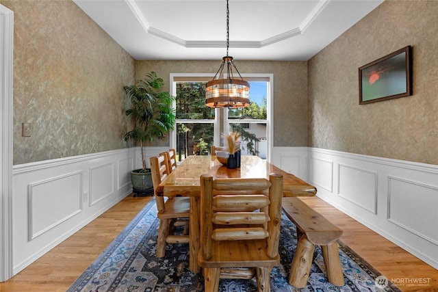 11024 127th Ave NE, Lake Stevens, WA 98258 - dining space with light wood-style flooring, a tray ceiling, a wainscoted wall, a chandelier, and a decorative wall