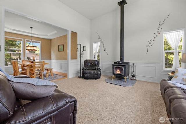 11024 127th Ave NE, Lake Stevens, WA 98258 - carpeted living room featuring a wood stove, healthy amount of natural light, wainscoting, a chandelier, and a decorative wall