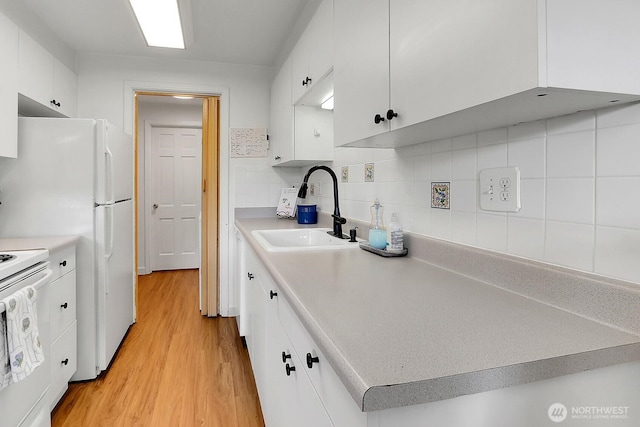 21120 77th Pl W Unit 104, Edmonds, WA 98026 - kitchen with a sink, white cabinets, light wood-style flooring, and light countertops