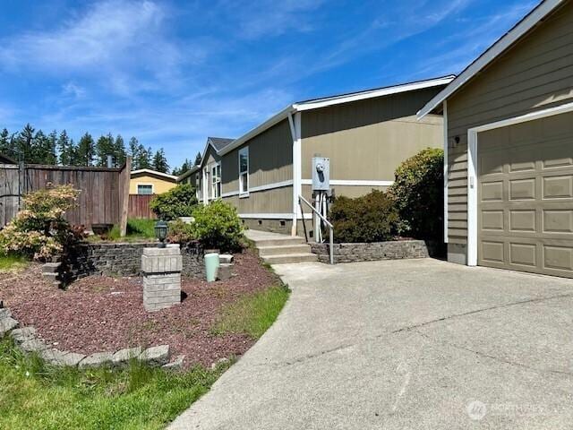 7725 203rd Street Ct E Unit 27, Spanaway, WA 98387 - view of side of property featuring concrete driveway and an attached garage