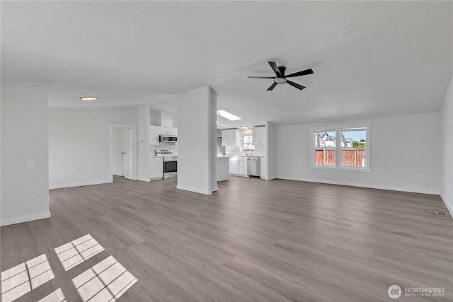 7725 203rd Street Ct E Unit 27, Spanaway, WA 98387 - unfurnished living room featuring ceiling fan, baseboards, and wood finished floors