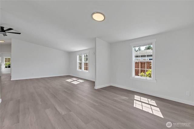 7725 203rd Street Ct E Unit 27, Spanaway, WA 98387 - unfurnished living room with healthy amount of natural light, baseboards, and wood finished floors