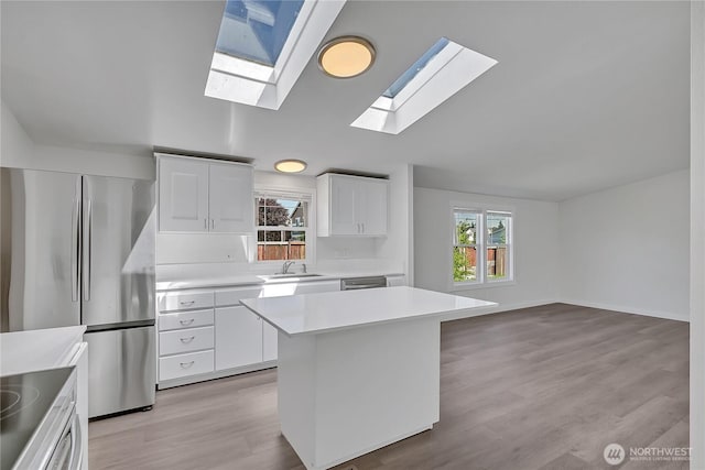 7725 203rd Street Ct E Unit 27, Spanaway, WA 98387 - kitchen with a sink, stainless steel appliances, lofted ceiling, light countertops, and a skylight