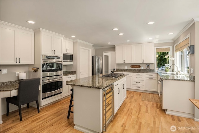 25819 NE 9th St, Sammamish, WA 98074 - kitchen featuring stainless steel appliances, crown molding, a kitchen island, light wood finished floors, and white cabinets