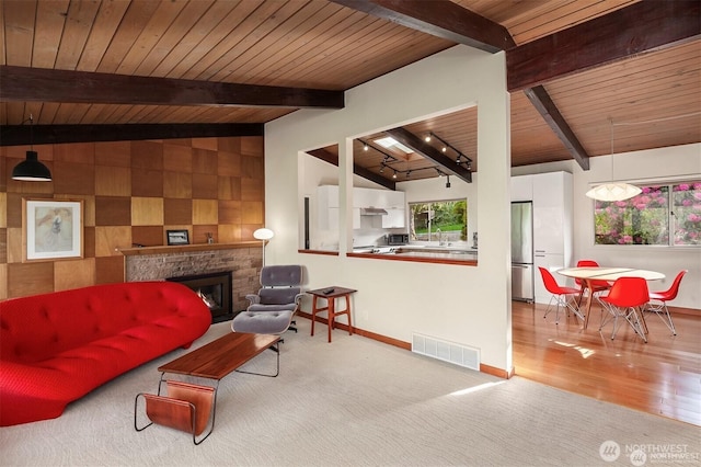 10762 Exeter Ave NE, Seattle, WA 98125 - living area featuring wooden ceiling, baseboards, a fireplace, carpet floors, and wood finished floors