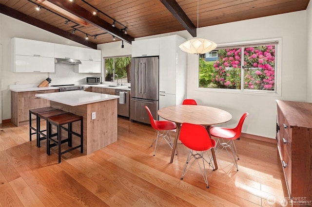 10762 Exeter Ave NE, Seattle, WA 98125 - kitchen with stainless steel appliances, wood ceiling, under cabinet range hood, light wood-style floors, and track lighting