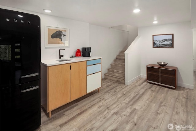 10762 Exeter Ave NE, Seattle, WA 98125 - bar with freestanding refrigerator, light wood finished floors, stairway, a sink, and baseboards