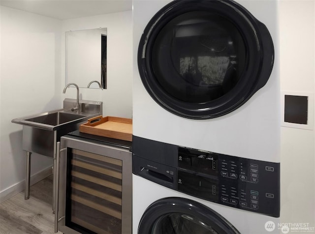 10762 Exeter Ave NE, Seattle, WA 98125 - laundry area featuring wine cooler, stacked washer / dryer, bar with sink, wood finished floors, and baseboards