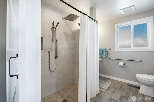 5691 Nakat Way, Blaine, WA 98230 - full bathroom featuring toilet, tiled shower, wood finished floors, and baseboards