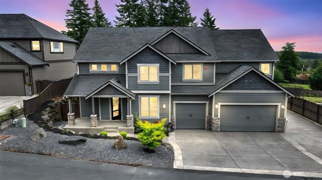 25625 SE Olympic Ln, Black Diamond, WA 98010 - craftsman-style house with a porch, driveway, a garage, stone siding, and a shingled roof
