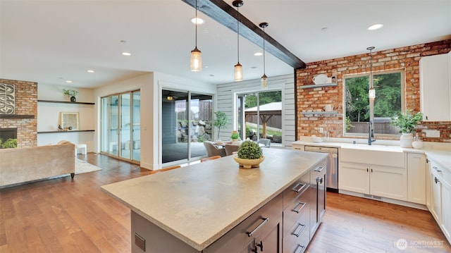 25625 SE Olympic Ln, Black Diamond, WA 98010 - kitchen with open floor plan, stainless steel dishwasher, a sink, pendant lighting, and white cabinets