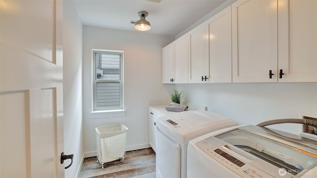 25625 SE Olympic Ln, Black Diamond, WA 98010 - laundry area featuring cabinet space, washing machine and clothes dryer, light wood-style flooring, and baseboards