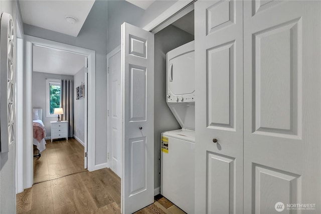 17311 119th Ln SE Unit J4, Renton, WA 98058 - washroom featuring stacked washer / dryer, wood finished floors, and baseboards