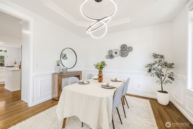 20347 86th Pl NE, Bothell, WA 98011 - dining area with wood finished floors, a decorative wall, a raised ceiling, crown molding, and a chandelier