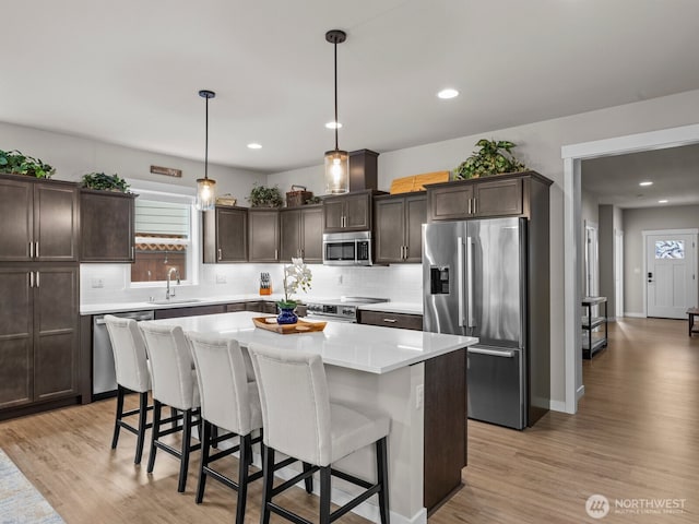 752 Parkland Loop, Sedro Woolley, WA 98284 - kitchen with appliances with stainless steel finishes, dark brown cabinets, light wood-style flooring, and recessed lighting