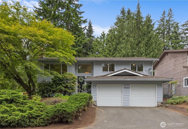 19203 Whitman Ave N, Shoreline, WA 98133 - bi-level home featuring asphalt driveway and an attached garage