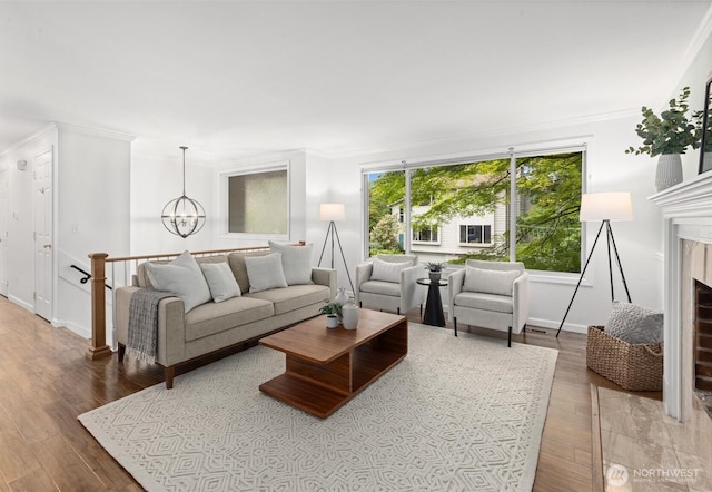 19203 Whitman Ave N, Shoreline, WA 98133 - living area featuring crown molding, a chandelier, wood finished floors, a premium fireplace, and baseboards