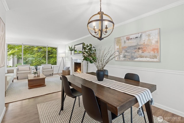 19203 Whitman Ave N, Shoreline, WA 98133 - dining room with a chandelier, a lit fireplace, wood finished floors, baseboards, and ornamental molding