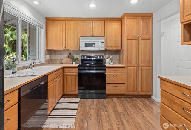 19203 Whitman Ave N, Shoreline, WA 98133 - kitchen with black appliances, light countertops, light wood-style floors, backsplash, and a sink