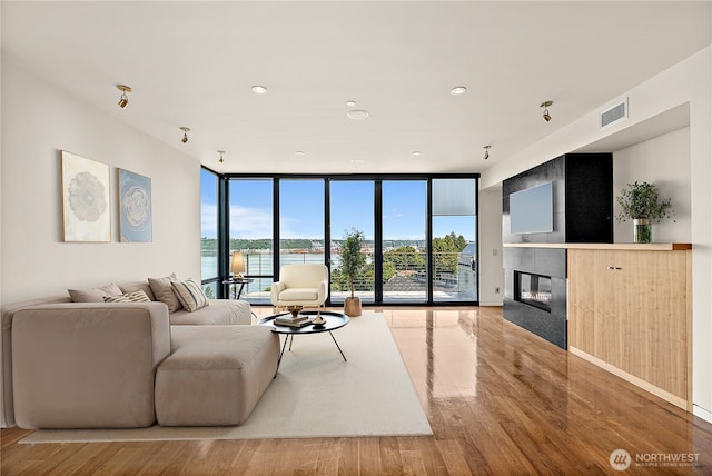 302 N Stadium Way Unit 302, Tacoma, WA 98403 - living room with floor to ceiling windows, wood finished floors, a fireplace, and recessed lighting