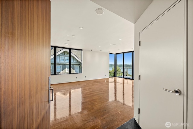 302 N Stadium Way Unit 302, Tacoma, WA 98403 - empty room with wood finished floors, a water view, recessed lighting, and expansive windows