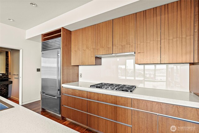 302 N Stadium Way Unit 302, Tacoma, WA 98403 - kitchen with appliances with stainless steel finishes, dark wood-style flooring, light countertops, open shelves, and baseboards