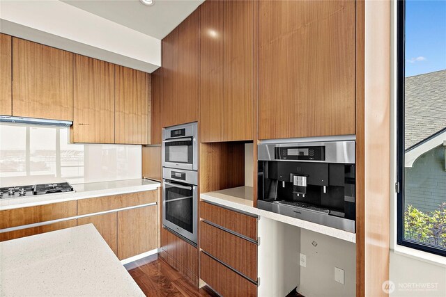 302 N Stadium Way Unit 302, Tacoma, WA 98403 - kitchen with stainless steel appliances, light countertops, dark wood-type flooring, exhaust hood, and modern cabinets