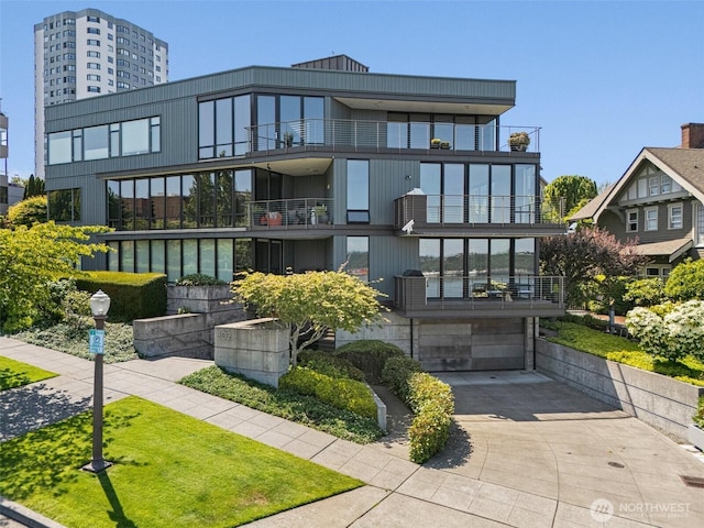 302 N Stadium Way Unit 302, Tacoma, WA 98403 - view of building exterior with concrete driveway and a garage