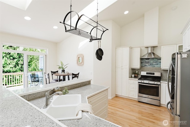 2921 Haggin St, Bellingham, WA 98226 - kitchen featuring appliances with stainless steel finishes, wall chimney exhaust hood, decorative backsplash, a sink, and white cabinets