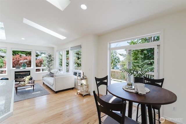 2921 Haggin St, Bellingham, WA 98226 - dining space with a skylight, plenty of natural light, light wood finished floors, and a glass covered fireplace