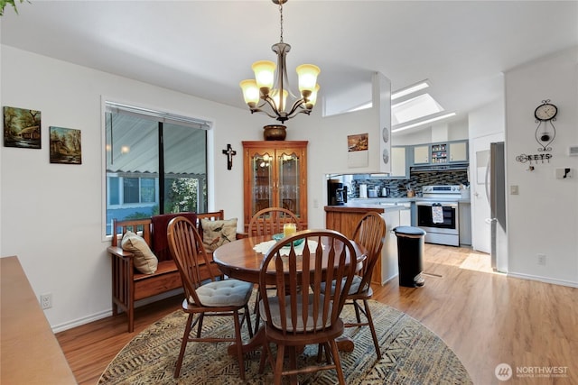 2259 Rincon Ave, Enumclaw, WA 98022 - dining room with a chandelier, light wood-style floors, lofted ceiling, and baseboards